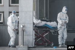 Doktorët trajtojnë një person që dyshohet se është prekur nga virusi i ri. Kinë, 18 janar, 2020.