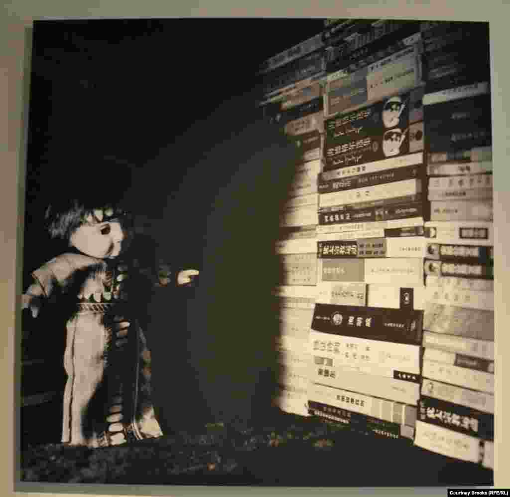 A doll stands surrounded by walls of books.