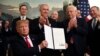 President Donald Trump holds up a signed proclamation recognizing Israel's sovereignty over the Golan Heights, as Israeli Prime Minister Benjamin Netanyahu looks on in the Diplomatic Reception Room of the White House in Washington, Monday, March 25, 2019.