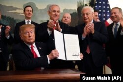 Дональд Трамп з підписаним документом, який визнає суверенітет Ізраїлю над Голанськими висотами. Прем’єр Нетаньягу стоїть поруч. Білий дім, Вашингтон, 2 березня 2019 року
