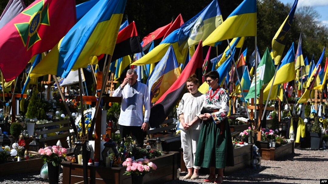 A family prays in front of a grave of a fallen Ukrainian soldier at a military cemetery on Easter Sunday in Lviv.