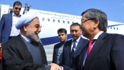 Iranian President Hassan Rohani (left) is welcomed at Bishkek's Manas Airport by Kyrgyz Prime Minister Jantoro Satybaldiev on September 12.