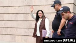 Armenia - Opposition figure Aregnaz Manukian waves to supporters as she is moved to house arrest, Yerevan, September 22, 2026.