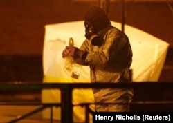 Members of the emergency services wearing protective clothing work on March 13 near the bench where former Russian intelligence officer Sergei Skripal and his daughter Yulia were found poisoned in Salisbury.