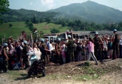 Dutch UN troops in Potocari stand alongside refugees from Srebrenica.