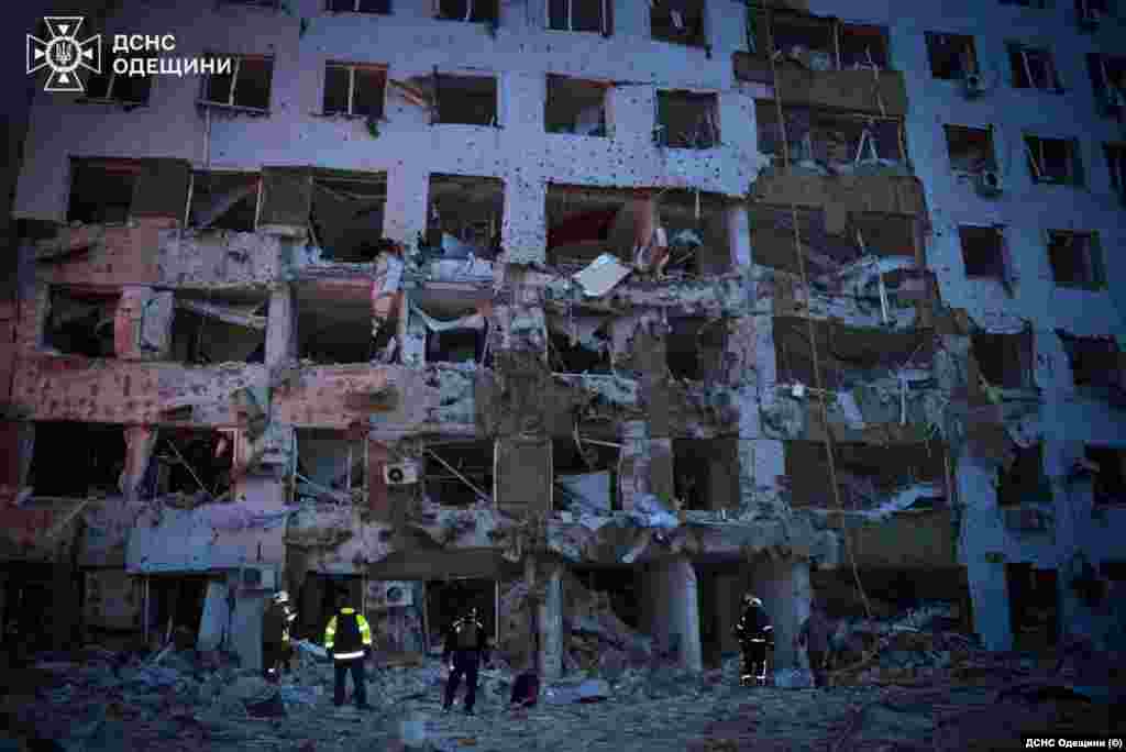 Рятувальники працюють на місці влучання російських дронів у багатоквартирний будинок в Одесі, 16 квітня 2026 року