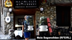 Туристы у входа в ресторан в грузинской столице.