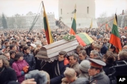 Huge crowds in Vilnius attend a funeral procession for 10 of the 14 people killed when Soviet troops stormed the Lithuanian broadcast center in January 1991.