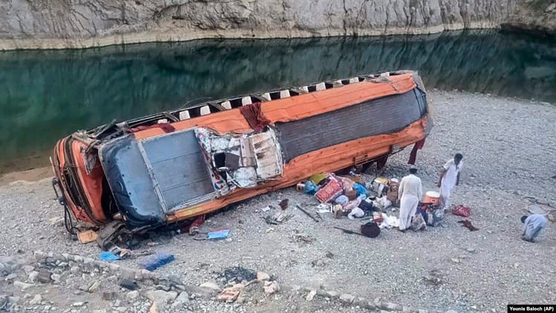 Locals stand by the damaged bus at the site of the accident in Khuzdar, a remote district in the Pakistan's southwestern Baluchistan Province on June 11.