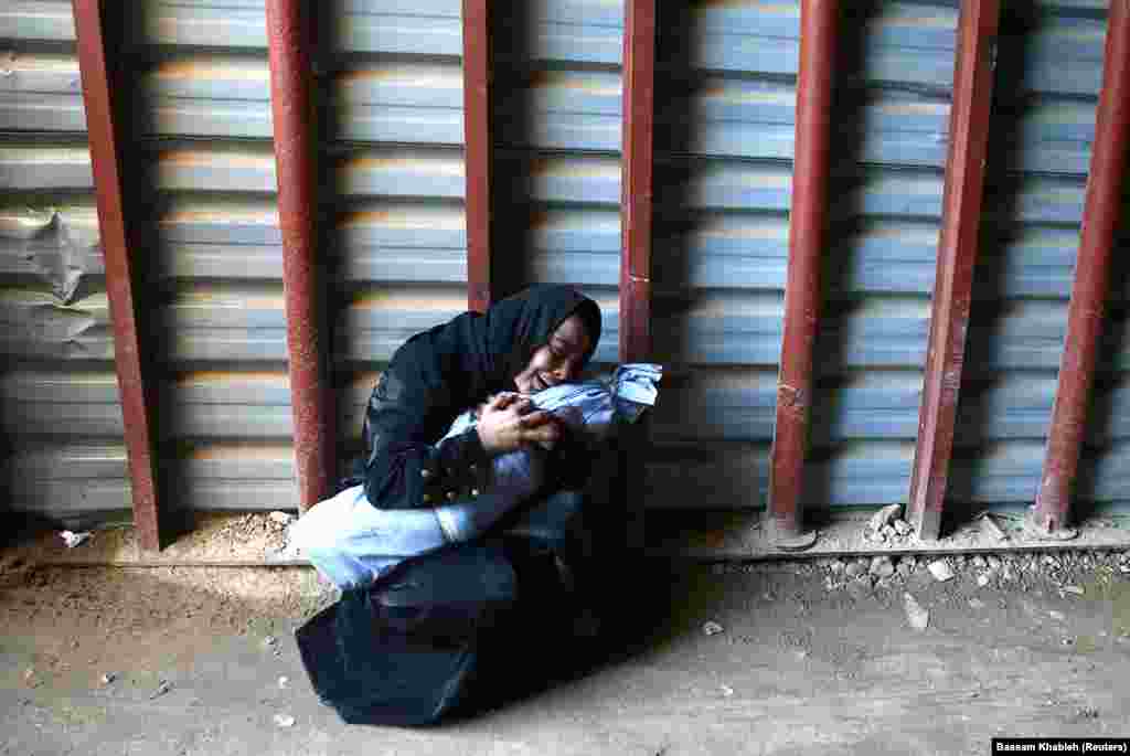 A woman mourns as she holds the body of her 2-year-old son at a medical center in the besieged town of Douma, Eastern Ghouta, near Damascus, Syria (Reuters/Bassam Khabieh)