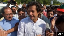 Pakistani cricketer-turned-politician Imran Khan (center) walks with supporters at a rally on the outskirts of Islamabad.