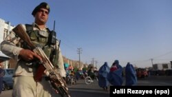 Afghan security official stands guard at a roadside checkpoint in Herat, Afghanistan, on August 3.