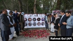 Mourners pray and light candles to pay tribute to Afghan journalists killed in a April 30 suicide attack in Kabul.