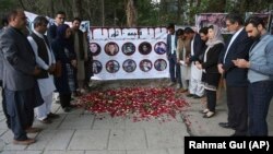 Mourners pray and light candles to pay tribute to Afghan journalists killed in a April 30 suicide attack in Kabul.