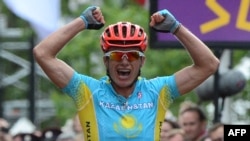 Kazakhstan's Alexandr Vinokourov celebrates as he crosses the finish line after winning the men's cycling road race event in London.