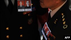 Turkish military officers wore photos of two slain Turkish soldiers at memorial services in Istanbul on October 21.