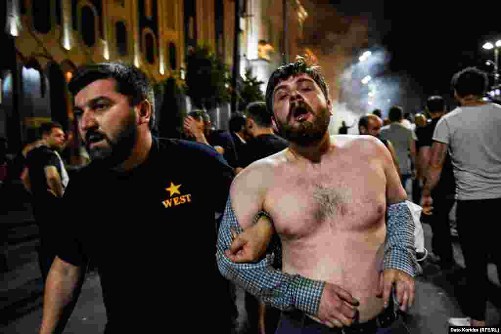 A man led away after tear gas was deployed by Georgian police.&nbsp;