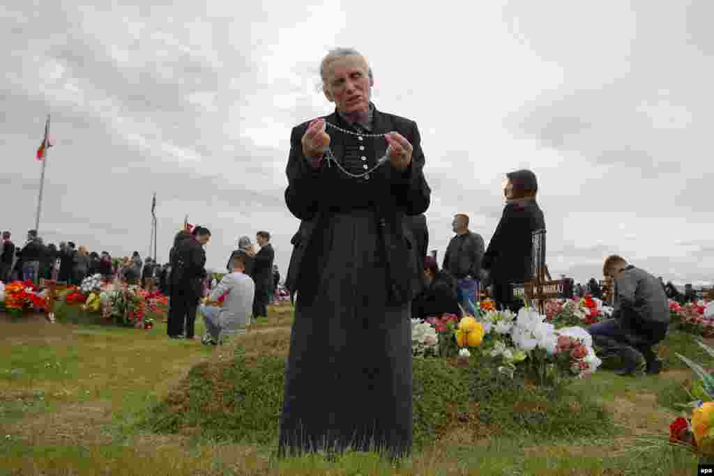 An ethnic Albanian woman prays in front of the grave of her son during a ceremony to mark the Day of Missing Persons for those who disappeared during the 1998-1999 war between Serb security forces and &nbsp;Albanian geurillas, at a cemetery in the village of Meje on April 27. (epa/Valdrin Xhemaj)