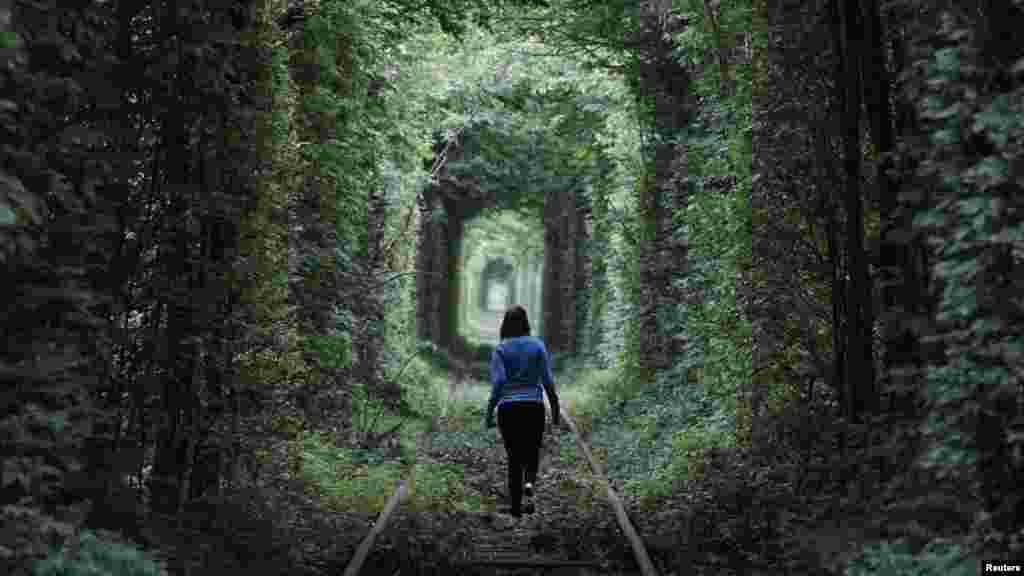 A girl walks on a disused railway track, through what is known locally as the "Tunnel of Love," in the Ukrainian town of Kleven. (Reuters/Gleb Granich)