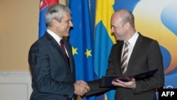 Serbian President Boris Tadic (left) shakes hands with Swedish Prime Minister Fredrik Reinfeldt in Stockholm on December 22, after submitting his country's application for EU membership.