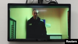 Aleksei Navalny is seen on a screen via video link during a court hearing in Moscow in April.