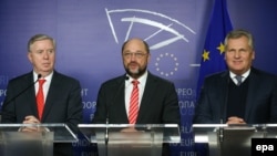 Бывший президент Европарламента П.Кокс и бывший президент Польши А.Квасьневский с президентом Европарламента М.Шульцем на пресс-конференции в Брюсселе
