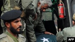 AERO Scouts shift the coffin of Punjab Governor Salman Taseer from a helicopter to the funeral location in Lahore, Pakistan, on January 5.