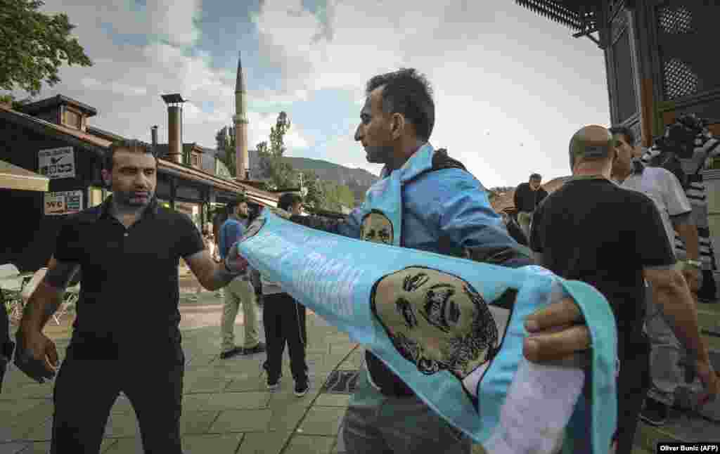 A man sells a scarf with an image of Turkish President Recep Tayyip Erdogan at the Bascarsija main square in Sarajevo on May 19, ahead of his visit for a campaign rally the next day. (AFP/Oliver Bunic)