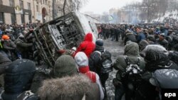 Мітингувальники перевертають згорівший автобус міліції, Київ, 21 січня 2014 року