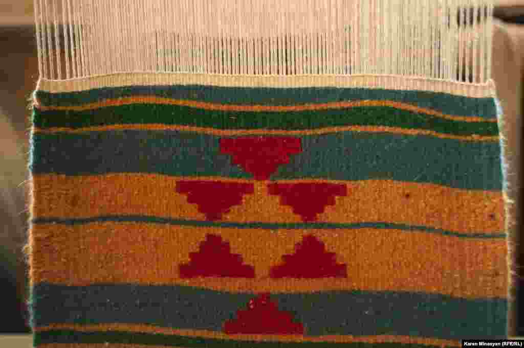 A patterned rug begins to emerge.