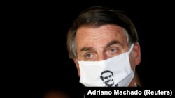 Бразильський президент Жаїр Болсонару спілкується з журналістами в захисній масці, 23 травня 2020 року