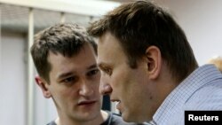 Russian opposition leader and anticorruption blogger Aleksei Navalny (front) and his brother and co-defendant Oleg attend a court hearing in Moscow on December 30.
