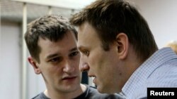 Russian opposition leader and anticorruption blogger Aleksei Navalny (front) and his brother and co-defendant Oleg attend a court hearing in Moscow in December 2014.