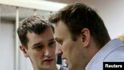 Российский оппозиционер Алексей Навальный (справа) и его брат Олег в суде, где рассматривается дело "Ив Роше".