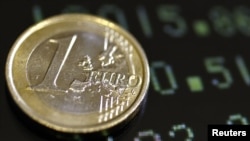 Italy -- A picture illustration shows a one euro coin on a flat screen displaying exchange rates in Rome, 08Dec2011