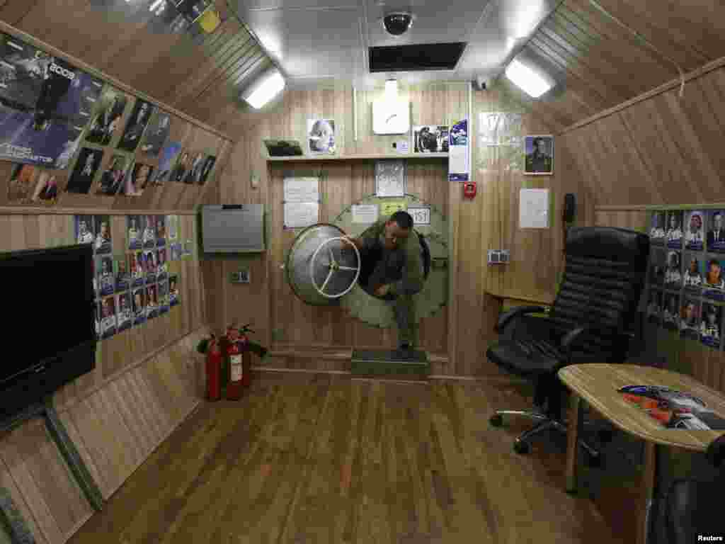 A technician works inside one of the aptly named "confinement modules."