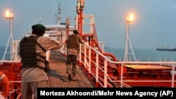 Two armed members of Iran's Revolutionary Guards Corps inspect the Stena Impero in the Iranian port of Bandar Abbas on July 21.