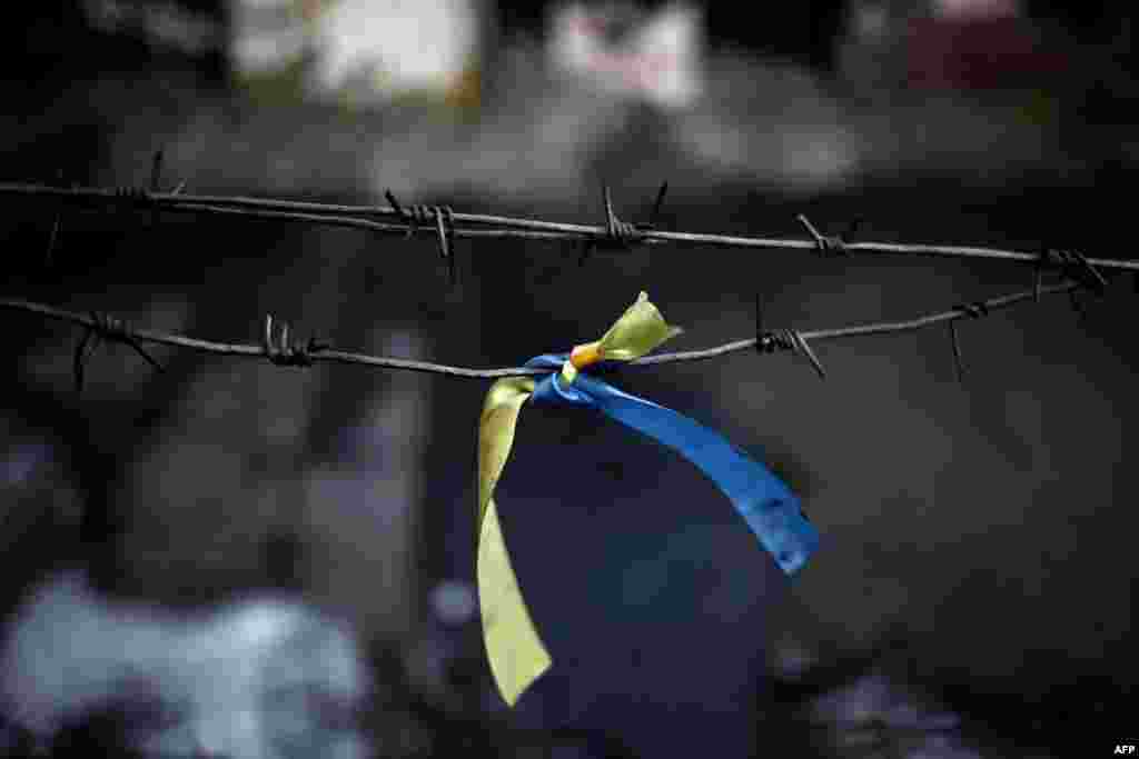 A ribbon with the colours of the Ukrainian flag is placed at a road block on Kyiv&#39;s Independence Square. (AFP/Angelos Tzortzinis)