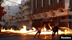 Zjarrfikësit në luftë me zjarrin i cili, sipas dëshmitarëve ishte shkaktuar nga një sulm ajror izraelit në Rripin e Gazës