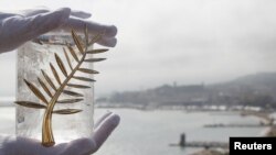 France -- A Chopard representative displays the Palme d'Or, the highest prize awarded to competing films, in Cannes, 11May2010