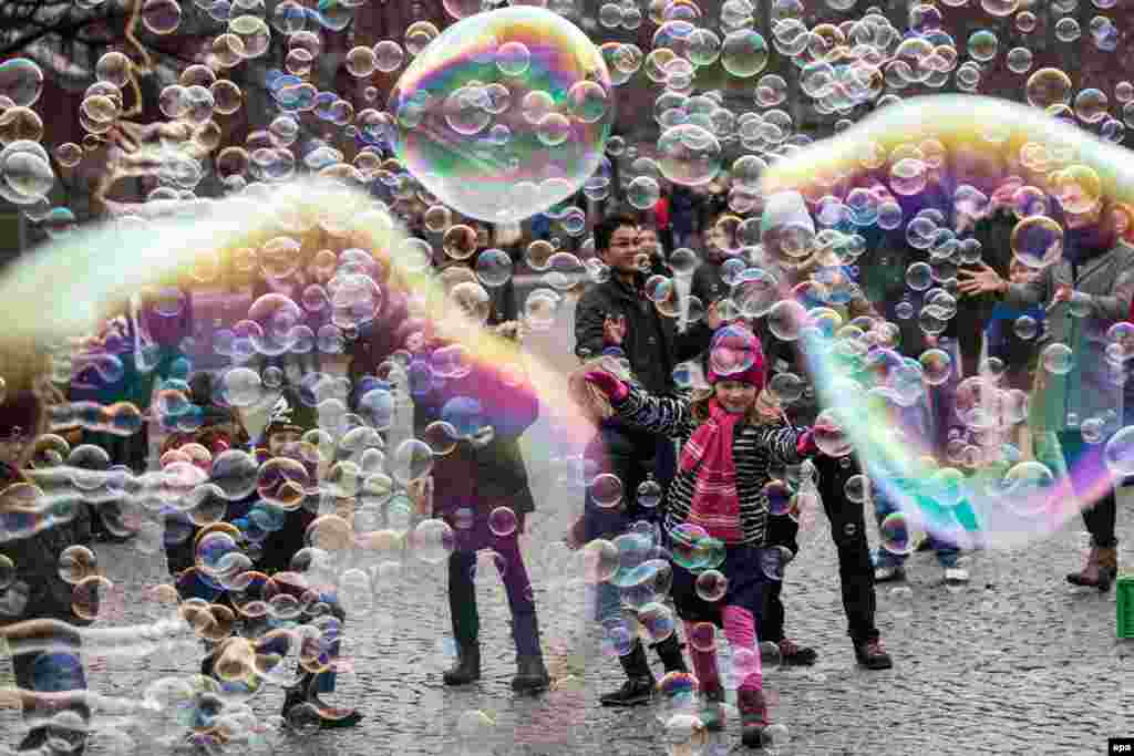 Visitors and children play with big and small bubbles in Cologne, Germany. (epa/Maja Hitij)