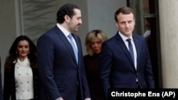 Lebanon's Prime Minister Saad Hariri (center) and his wife, Lara (left), leave after a lunch with French President Emmanuel Macron (right) and his wife, Brigitte (second from right), at the Elysee Palace in Paris on November 18.