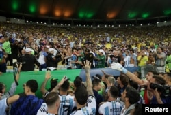 Lionel Messi me bashkëlojtarët e tij argjentinas tentojnë t'i qetësojnë tifozët gjatë përleshjes së tyre me stafin e sigurimit në stadiumin Maracana në Rio de Zhaniero, 21 nëntor 2023.