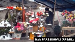 Вокруг строительного забора под открытым небом вот уже четыре года ютятся продавцы цветов. Им обещают, что в этом строящемся павильоне им выделят площади для небольших магазинчиков