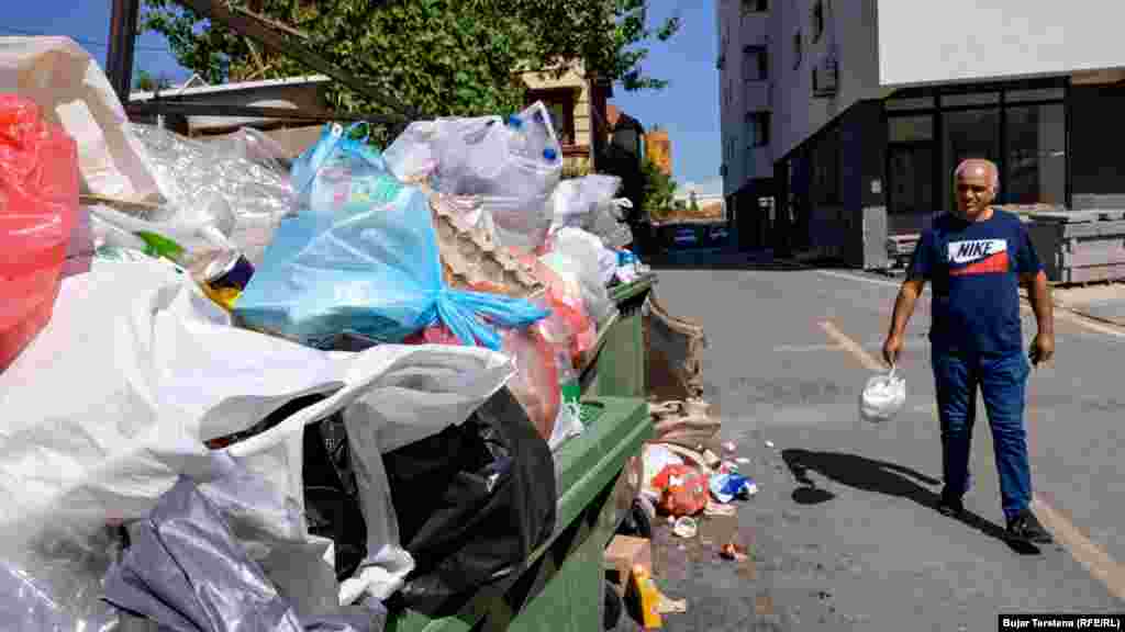 Rafet Berisha duke hedhur mbeturina në kontejnerët e stërmbushur në Fushë Kosovë. Ai i tha Radios Evropa e Lirë në shtator se trotuaret janë të bllokuara nga makinat, ndërsa grumbuj mbeturinash shihen pothuajse në çdo lagje.Menaxhimi i keq i mbeturinave është ndër telashet e përditshme që përballen banorët e kësaj komune pranë kryeqytetit.