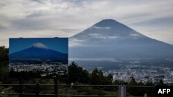 Znak sa fotografijom planine Fudži prekrivene snijegom na vidikovcu sa kojeg se pruža pogled na najvišu planinu u Japanu, 31. oktobra 2024.