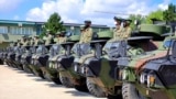 KOSOVO -- Kosovo Security Force soldiers sit on top of armored Security vehicles donated by U.S 