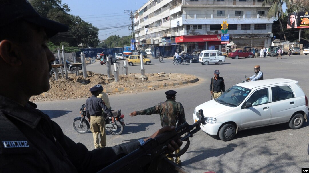 Policemen stand guard at a security checkpoint in Karachi.