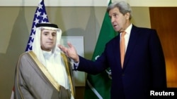 U.S. Secretary of State John Kerry (right) gestures next to Saudi Foreign Minister Adel al-Jubeir in Geneva on May 2