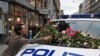 A woman places flowers on a police vehicle after a memorial march to mourn for the victims of the killing spree and bomb blast in Oslo on July 25.